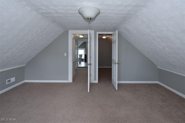 bonus room with carpet flooring, vaulted ceiling, and a textured ceiling