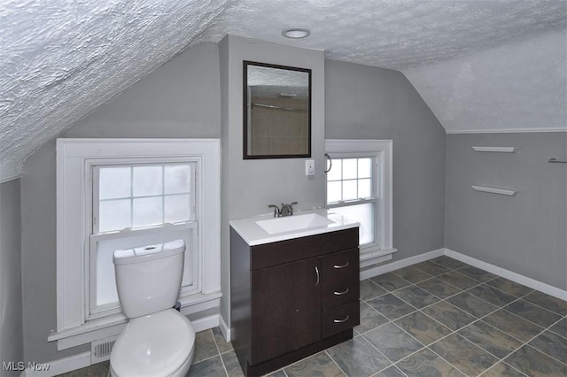 bathroom featuring toilet, a textured ceiling, vanity, and lofted ceiling