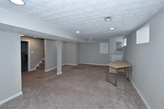 basement featuring electric panel, carpet floors, and a textured ceiling