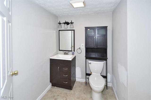 bathroom featuring a textured ceiling, toilet, vanity, and tile patterned flooring