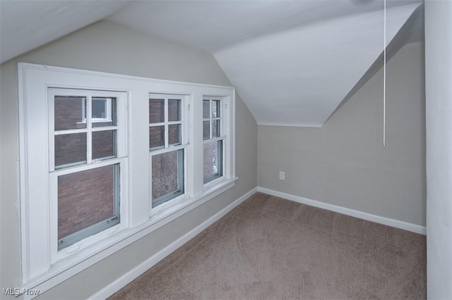 bonus room with light carpet and vaulted ceiling