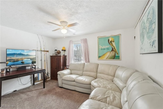 living room with ceiling fan, carpet floors, and a textured ceiling