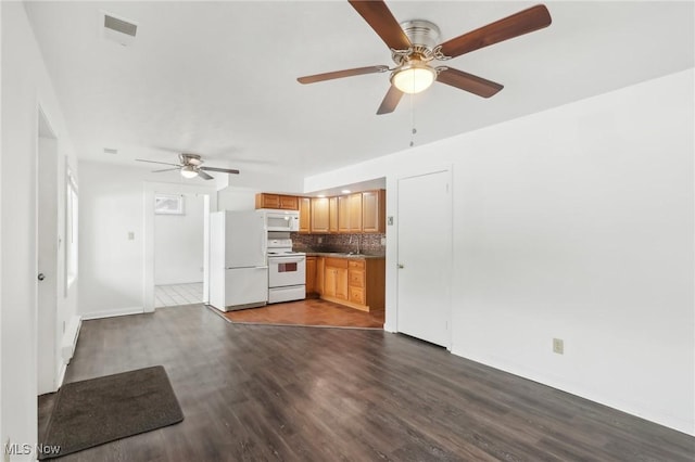 kitchen with dark wood-type flooring, white appliances, ceiling fan, backsplash, and sink