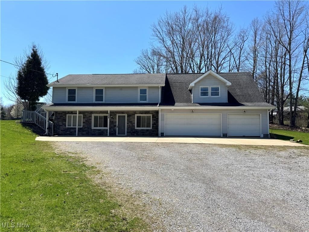 8961 Herbert Rd, Canfield, OH 44406 - traditional-style home with stone siding, driveway, a front yard, and a garage