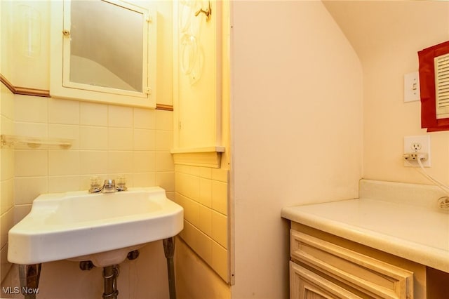 bathroom featuring sink and tile walls