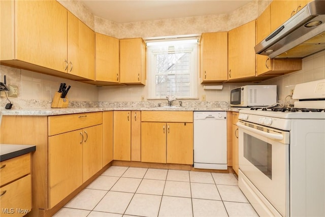 kitchen with white appliances, light tile patterned floors, sink, and decorative backsplash