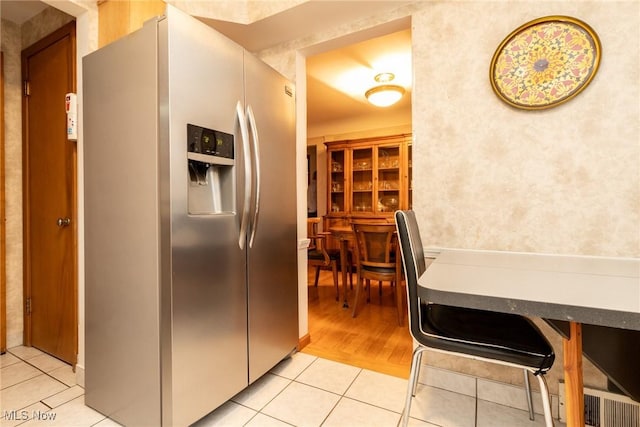 kitchen with stainless steel fridge with ice dispenser and light tile patterned floors