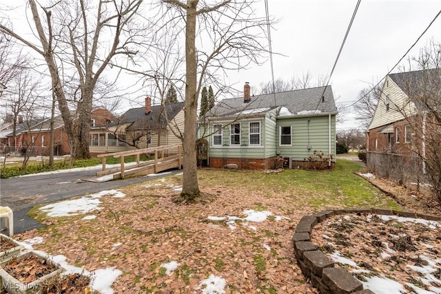 rear view of house featuring a lawn