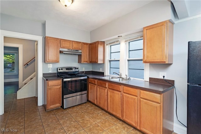 kitchen with light tile patterned floors, sink, black fridge, and stainless steel electric stove