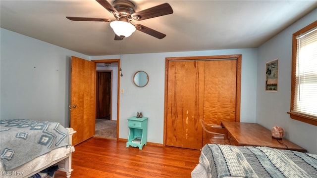 bedroom featuring multiple windows, a closet, hardwood / wood-style flooring, and ceiling fan