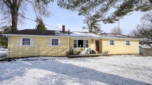 view of snow covered rear of property