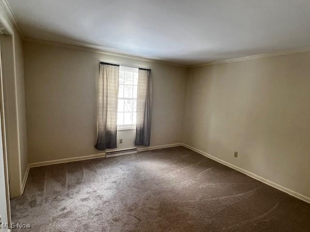 carpeted empty room featuring a baseboard heating unit and crown molding