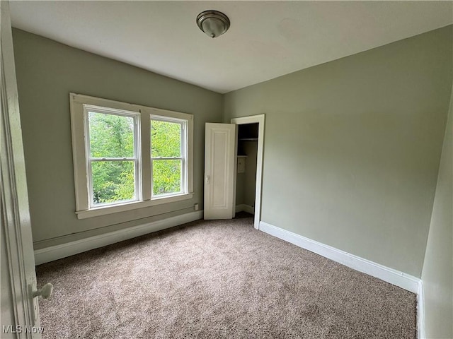 unfurnished bedroom featuring carpet and a closet