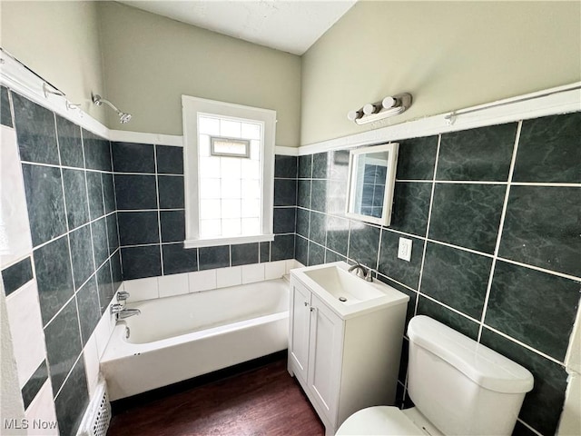 full bathroom featuring hardwood / wood-style floors, tile walls, vanity, toilet, and  shower combination