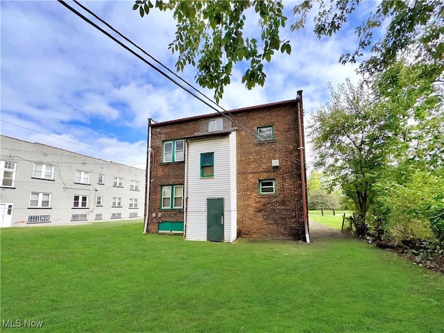 back of property featuring a yard