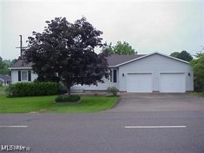 view of front of house featuring a garage and a front lawn