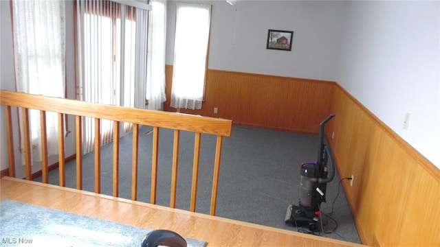 stairs with wooden walls and hardwood / wood-style floors