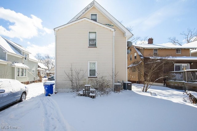 snow covered property featuring central AC