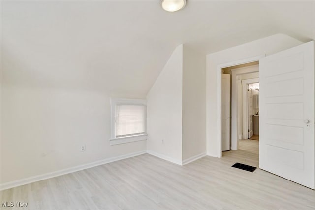 bonus room with light hardwood / wood-style floors and vaulted ceiling