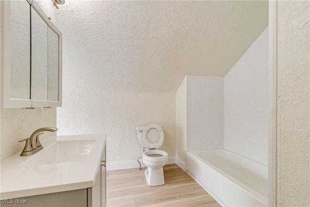 full bathroom with shower / bathing tub combination, toilet, a textured ceiling, hardwood / wood-style floors, and vanity