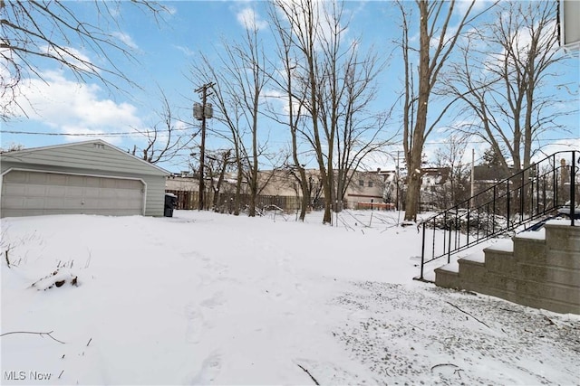 yard layered in snow featuring a garage