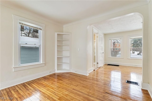 spare room with light hardwood / wood-style floors and crown molding