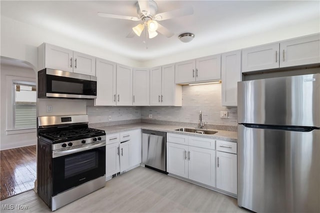 kitchen with white cabinets, appliances with stainless steel finishes, sink, and tasteful backsplash