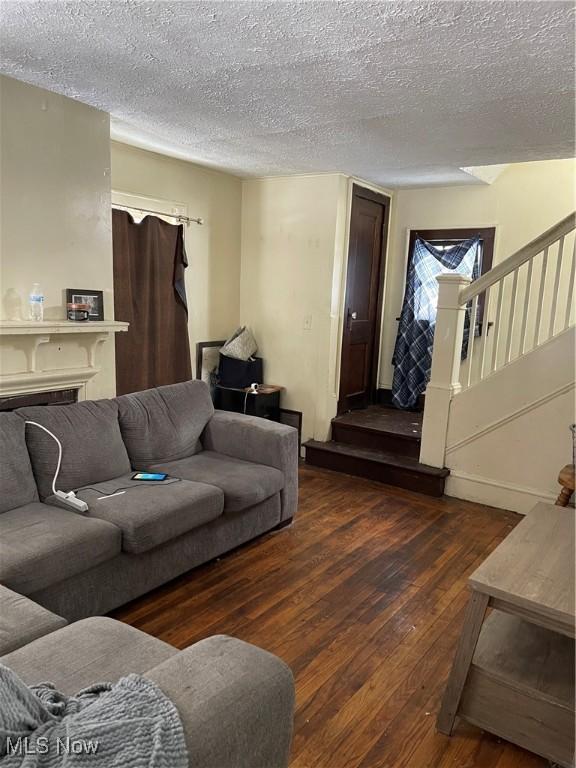 living room with dark hardwood / wood-style flooring and a textured ceiling