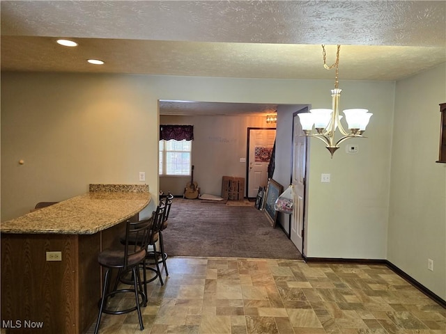 dining space with an inviting chandelier, baseboards, a textured ceiling, and recessed lighting