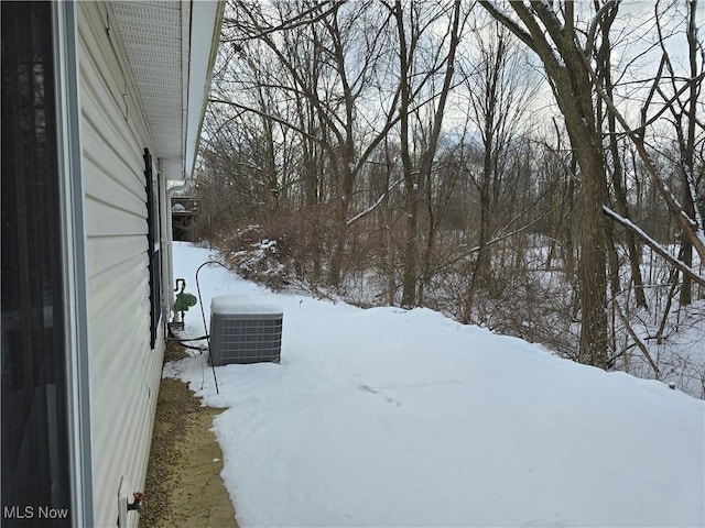 yard layered in snow featuring central AC unit