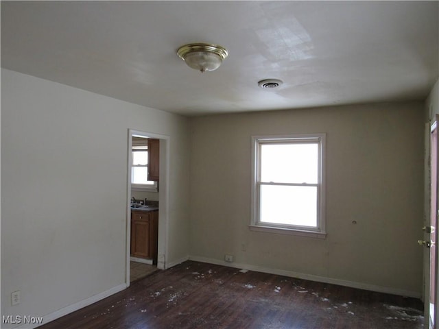 empty room featuring sink and dark hardwood / wood-style floors