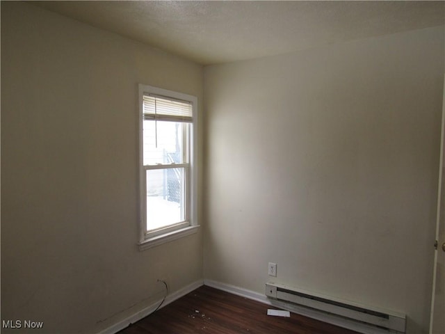 unfurnished room featuring a baseboard radiator and dark hardwood / wood-style flooring