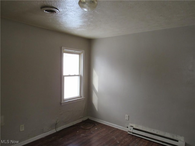 spare room with a textured ceiling, dark hardwood / wood-style floors, and a baseboard radiator