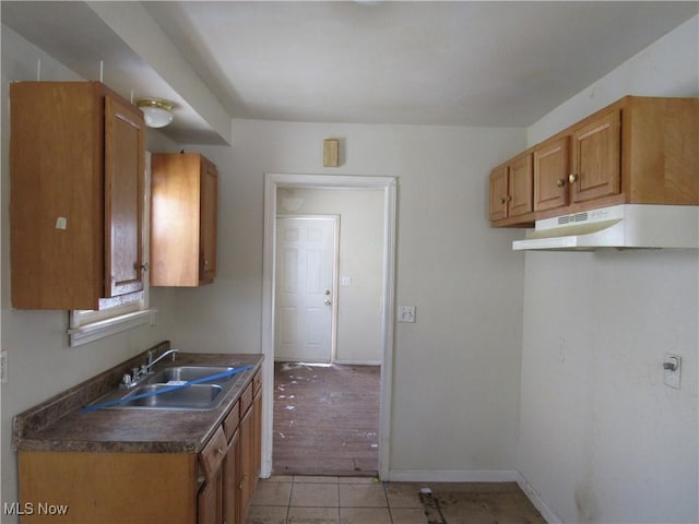 kitchen with light tile patterned flooring, sink, and dishwashing machine