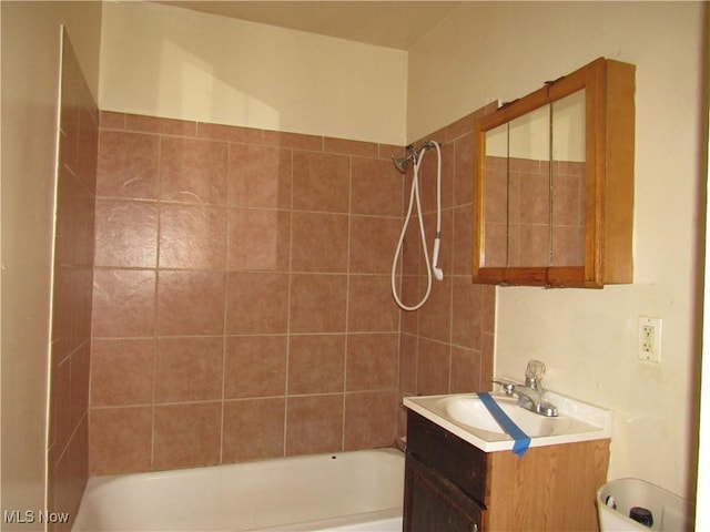 bathroom featuring vanity and tiled shower / bath