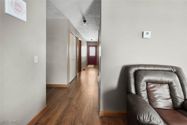 hallway featuring dark hardwood / wood-style flooring and a textured ceiling