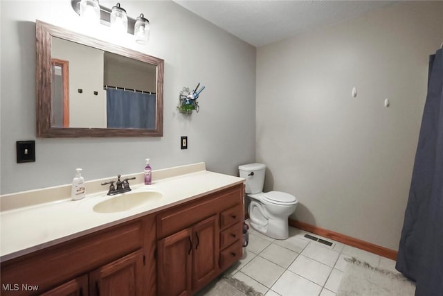 bathroom featuring toilet, vanity, and tile patterned flooring