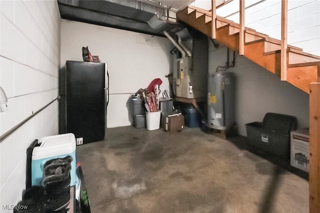 basement featuring heating unit, water heater, and black fridge