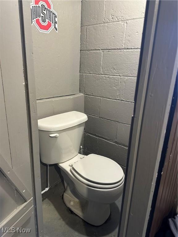 bathroom with concrete floors and toilet