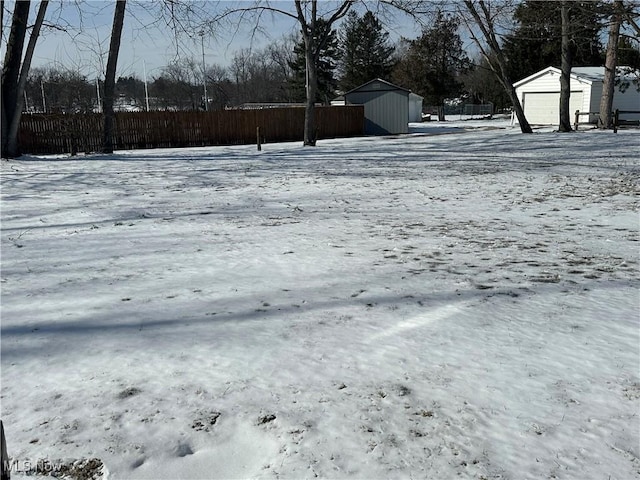 yard covered in snow featuring a storage shed