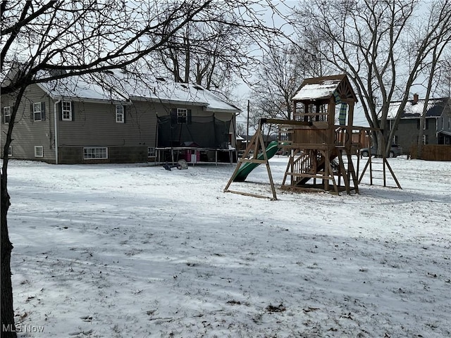 snow covered playground featuring a trampoline