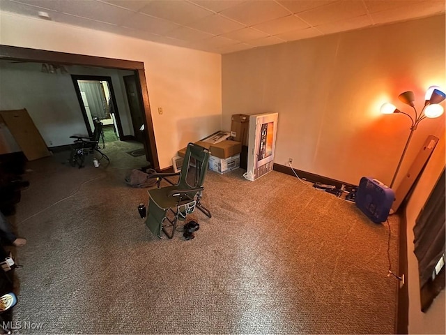 misc room featuring baseboards, carpet flooring, and a paneled ceiling