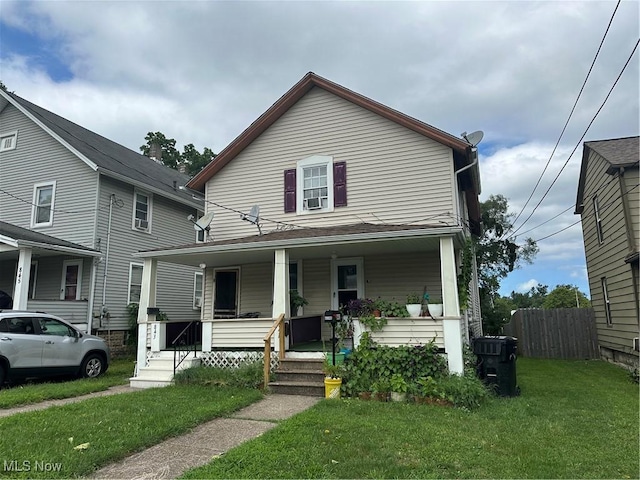 view of front of property featuring a front yard, a porch, and fence