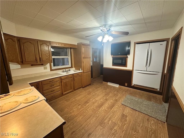 1425 Flint Ridge Rd, Hopewell, OH 43746 - kitchen featuring stovetop, ceiling fan, light hardwood / wood-style floors, white fridge, and sink