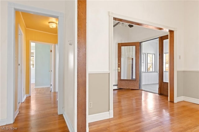 hall with baseboards and light wood-style flooring
