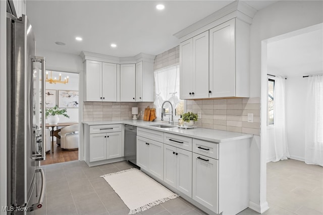 kitchen featuring white cabinetry, stainless steel appliances, backsplash, and sink