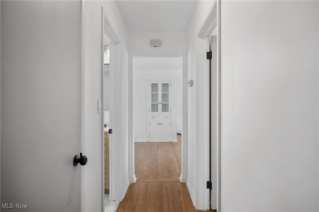 hallway with light hardwood / wood-style floors