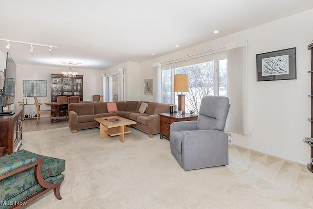 living room with light carpet, a chandelier, and rail lighting