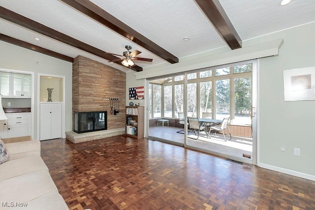 unfurnished living room featuring a large fireplace, plenty of natural light, lofted ceiling with beams, and dark parquet floors