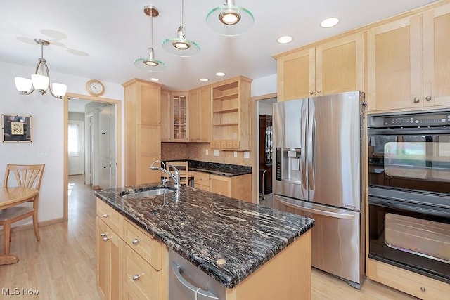 kitchen featuring a center island with sink, double oven, light brown cabinets, sink, and stainless steel fridge with ice dispenser